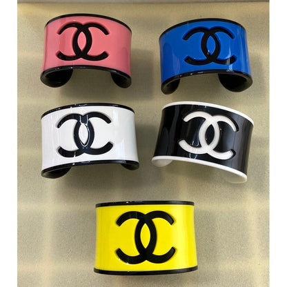 Set of colorful Chanel logo cuffs on a textured beige background