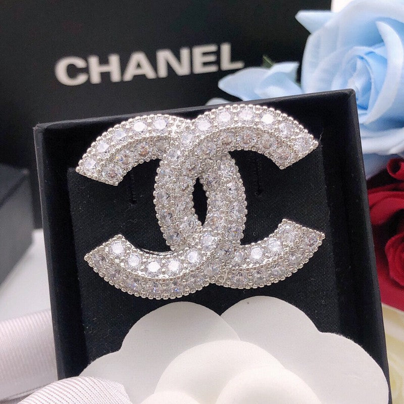 Chanel brooch with crystals on a black box with Chanel branding